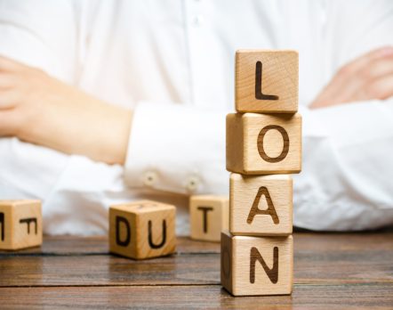 Wooden blocks with the word loan and businessman